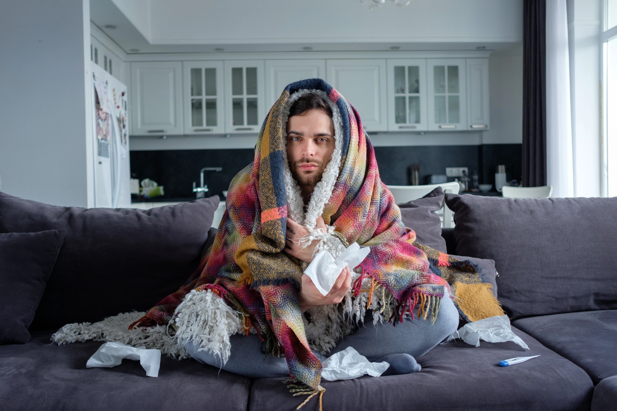 Person unwell with flu symptoms resting at home in winter, considering an online medical certificate